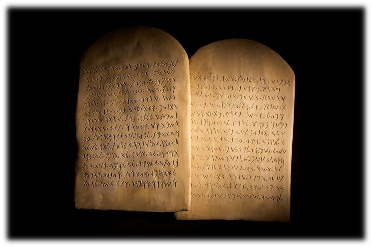 Two rounded stone tablets standing side by side, inscribed with lines of ancient Hebrew lettering